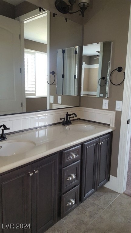 bathroom with tile patterned flooring, vanity, and ceiling fan