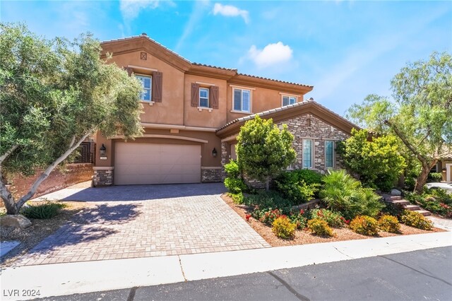 2804 Josephine Dr, Henderson, NV 89044 - mediterranean / spanish house with stone siding, an attached garage, decorative driveway, and stucco siding