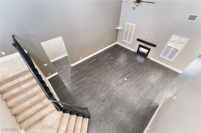 2804 Josephine Dr, Henderson, NV 89044 - unfurnished living room with ceiling fan, stairs, a glass covered fireplace, baseboards, and wood finished floors