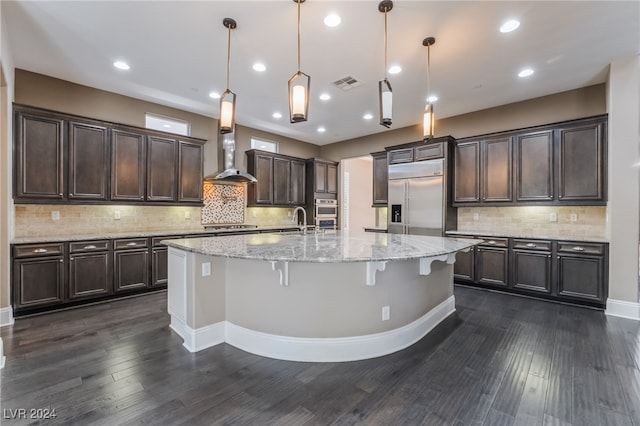2804 Josephine Dr, Henderson, NV 89044 - kitchen with appliances with stainless steel finishes, wall chimney exhaust hood, dark brown cabinetry, decorative backsplash, and a sink