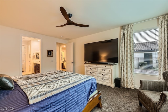 carpeted bedroom featuring ceiling fan and ensuite bath