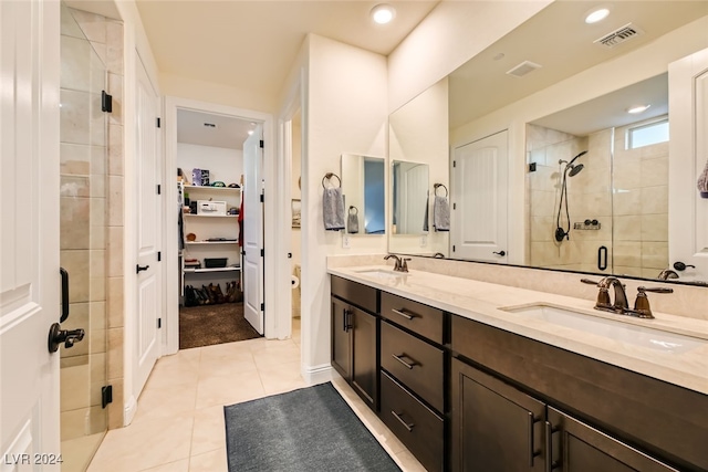 bathroom featuring tile patterned flooring, vanity, and a shower with shower door