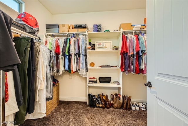 walk in closet with dark colored carpet