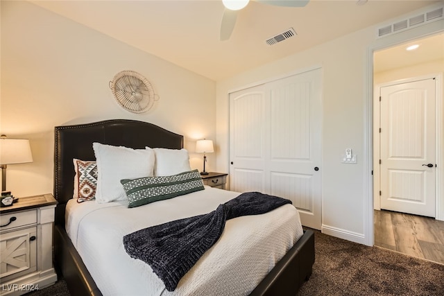 bedroom with dark hardwood / wood-style flooring, a closet, and ceiling fan