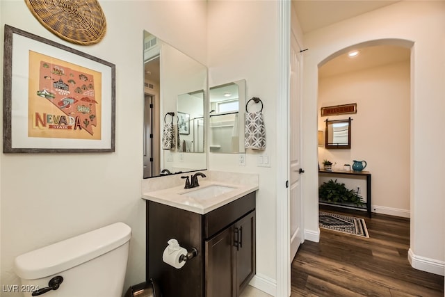 bathroom with hardwood / wood-style floors, vanity, and toilet