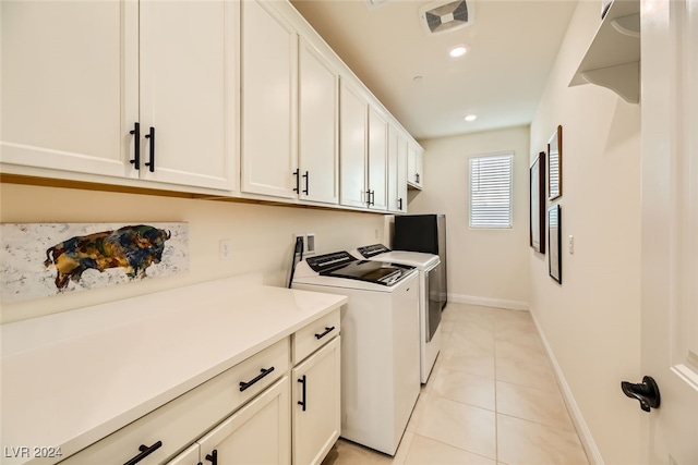 washroom featuring cabinets, light tile patterned floors, and washing machine and dryer