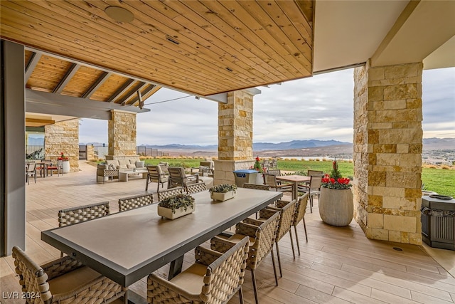 view of patio / terrace with a mountain view and an outdoor living space with a fireplace