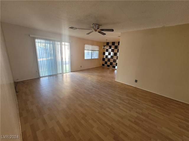 spare room with a textured ceiling, hardwood / wood-style flooring, and ceiling fan