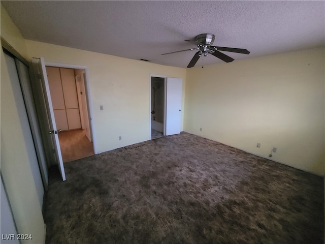 unfurnished bedroom with dark colored carpet, a textured ceiling, and ceiling fan