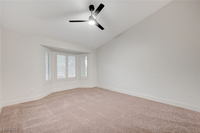 empty room with ceiling fan, lofted ceiling, and light carpet