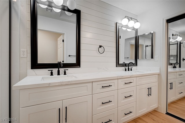 bathroom featuring vanity, hardwood / wood-style flooring, and wood walls