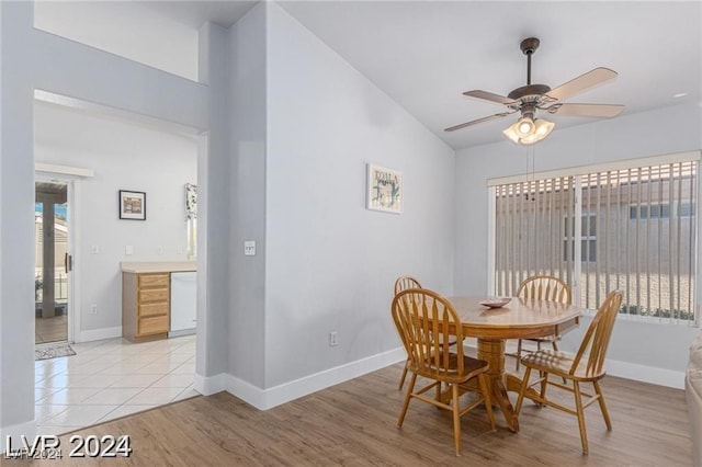 dining room featuring ceiling fan, light wood-type flooring, and lofted ceiling