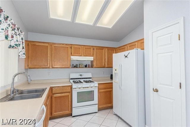 kitchen featuring light tile patterned floors, white appliances, lofted ceiling, and sink