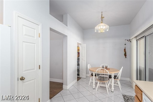 tiled dining room with an inviting chandelier