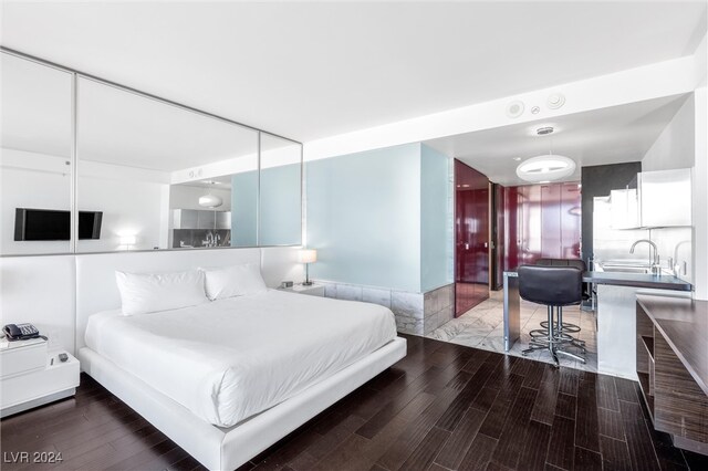 bedroom with hardwood / wood-style floors and sink