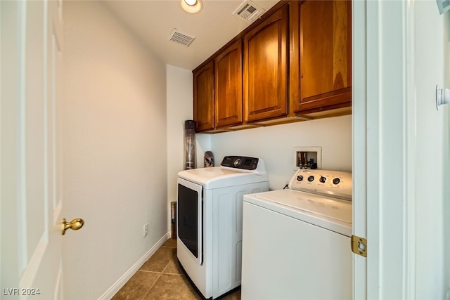 laundry area with cabinets, light tile patterned floors, and washer and clothes dryer