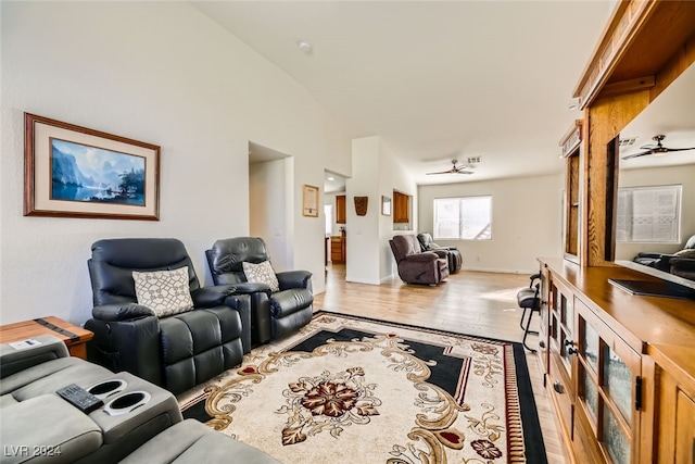 living room with ceiling fan, vaulted ceiling, and light hardwood / wood-style flooring