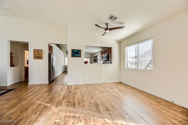 unfurnished living room featuring ceiling fan, light wood-type flooring, and lofted ceiling