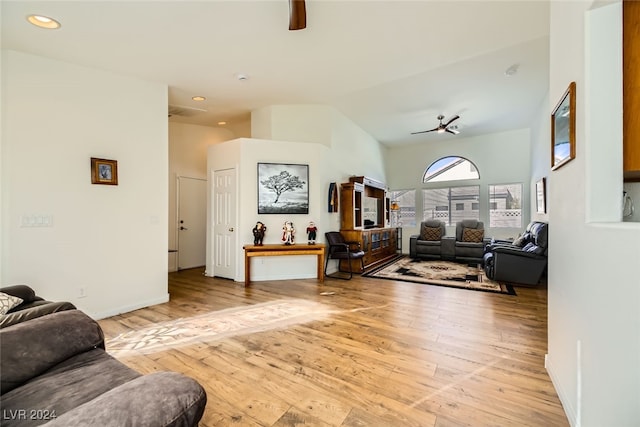 living room featuring ceiling fan, light hardwood / wood-style floors, and lofted ceiling