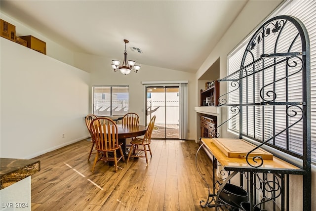 dining room featuring a chandelier, lofted ceiling, and wood-type flooring