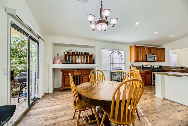 dining room featuring vaulted ceiling, light hardwood / wood-style flooring, a notable chandelier, and sink