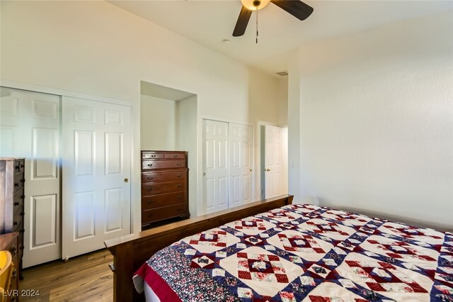 bedroom featuring multiple closets, ceiling fan, and wood-type flooring