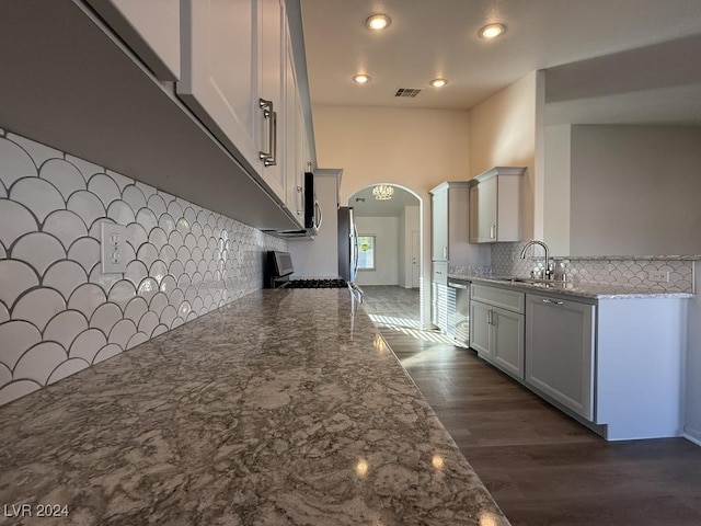 kitchen with stone countertops, white cabinetry, sink, and dark wood-type flooring