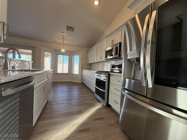 kitchen with dark hardwood / wood-style floors, white cabinets, stainless steel appliances, and vaulted ceiling