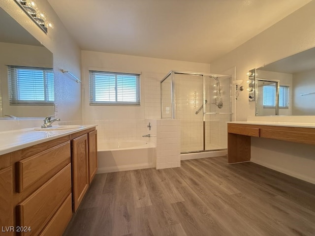 bathroom with hardwood / wood-style floors, vanity, and separate shower and tub