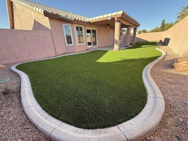 back of house with a lawn, ceiling fan, and a patio