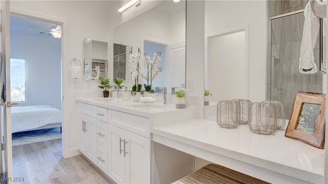 bathroom featuring hardwood / wood-style flooring, vanity, ceiling fan, and a shower with door