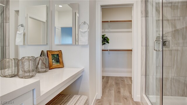 bathroom with vanity, wood-type flooring, and walk in shower