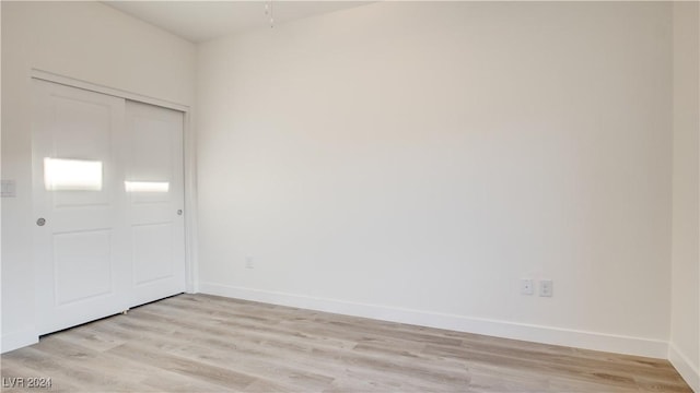 unfurnished bedroom featuring a closet and light wood-type flooring