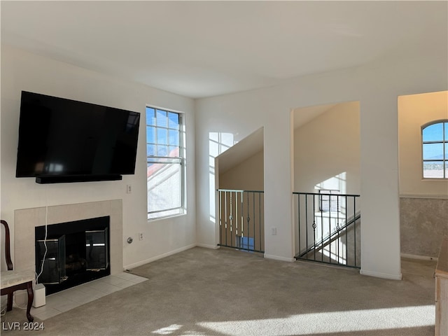 unfurnished living room with light carpet and a fireplace