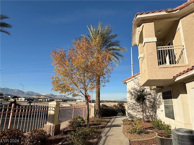 view of yard with a mountain view, a balcony, and central AC