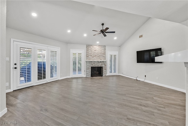 unfurnished living room with ceiling fan, light wood-type flooring, a fireplace, and vaulted ceiling