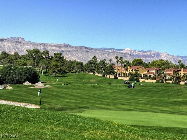 view of property's community with a lawn and a mountain view