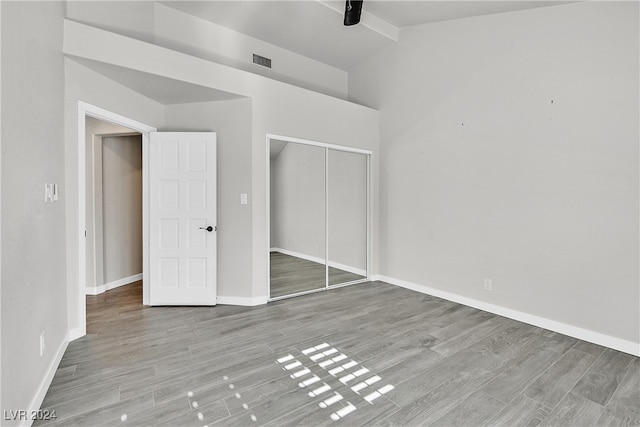 unfurnished bedroom featuring light hardwood / wood-style flooring, a closet, and ceiling fan