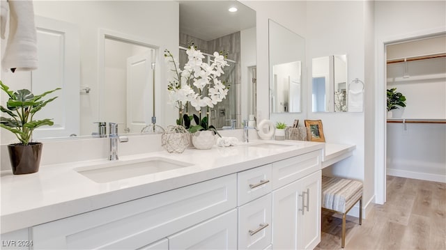 bathroom featuring wood-type flooring, vanity, and a shower with door