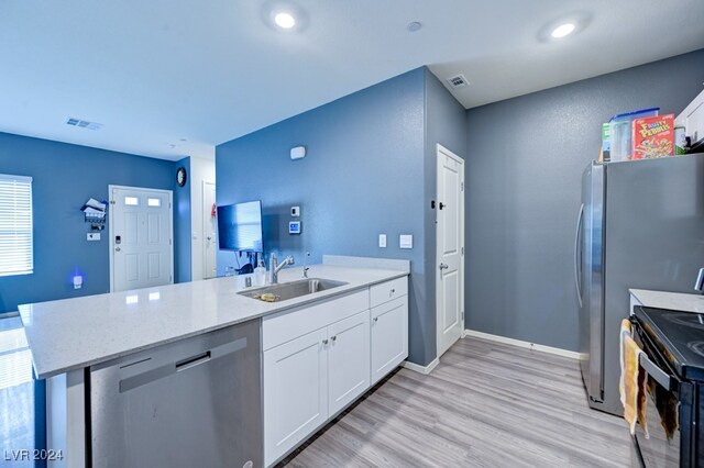 kitchen featuring sink, kitchen peninsula, light hardwood / wood-style flooring, stainless steel dishwasher, and white cabinetry