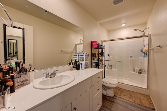 bathroom featuring walk in shower, toilet, vanity, and hardwood / wood-style flooring