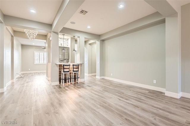 interior space featuring light hardwood / wood-style flooring and ceiling fan with notable chandelier