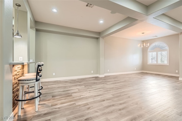 living room with beam ceiling, light hardwood / wood-style flooring, bar, and a notable chandelier