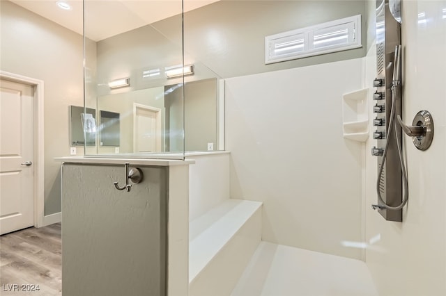 bathroom featuring hardwood / wood-style flooring and walk in shower