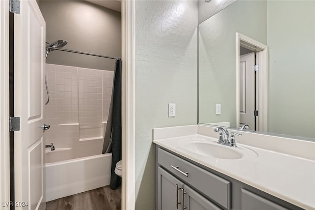 full bathroom with hardwood / wood-style flooring, vanity, shower / bath combination with curtain, and toilet