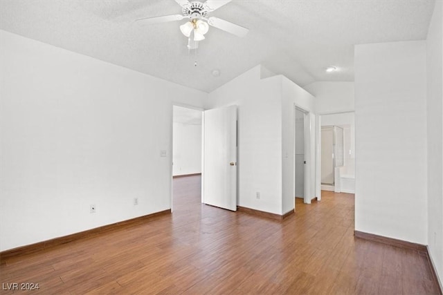 spare room with ceiling fan, a textured ceiling, baseboards, and wood finished floors