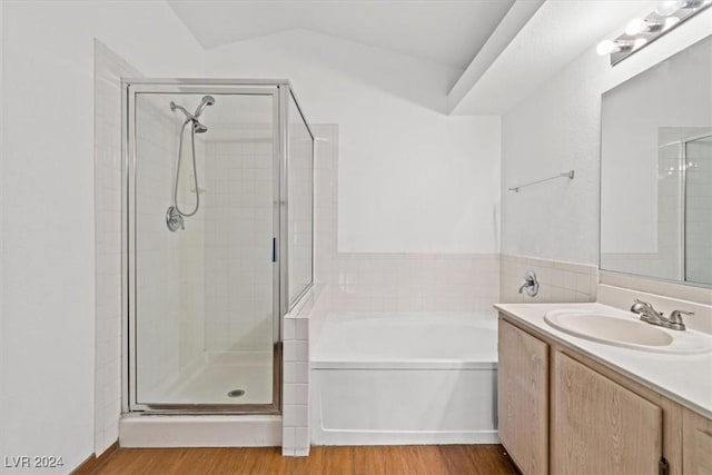 bathroom featuring vanity, wood finished floors, a shower stall, and a bath