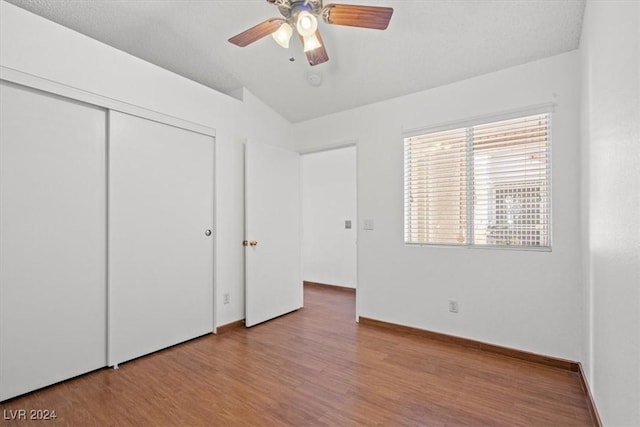 unfurnished bedroom with ceiling fan, a closet, baseboards, and wood finished floors