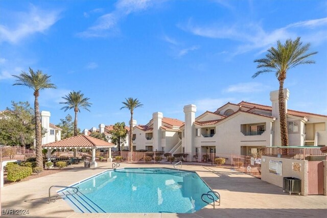 pool featuring a residential view, a patio area, fence, and a gazebo