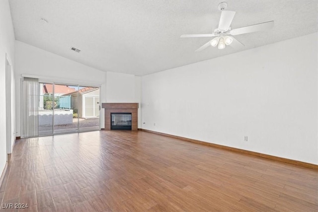 unfurnished living room featuring visible vents, a ceiling fan, a glass covered fireplace, wood finished floors, and baseboards